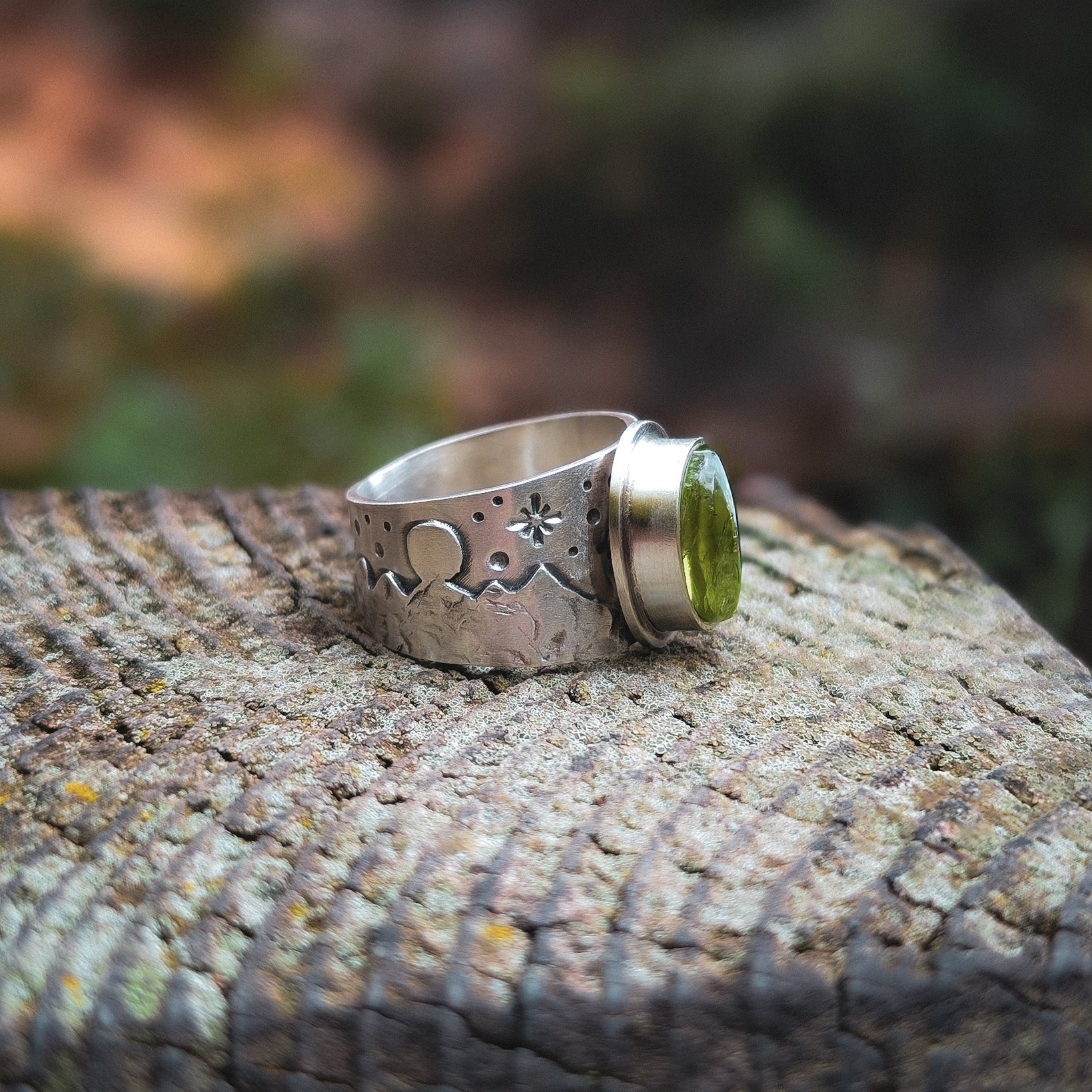 Anillo de plata con montañas y peridoto