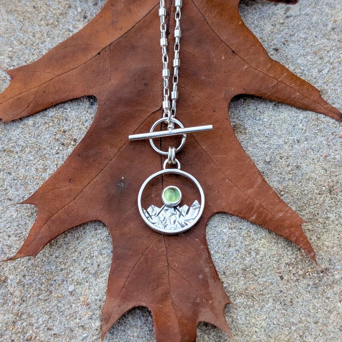 ARAN - Colgante de plata con montañas y peridoto