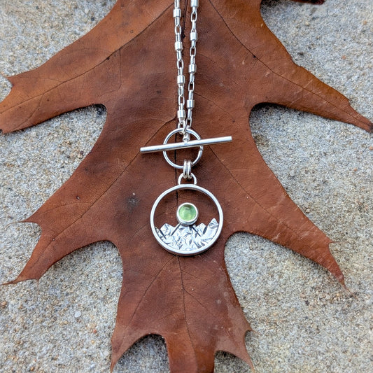 ARAN - Colgante de plata con montañas y peridoto