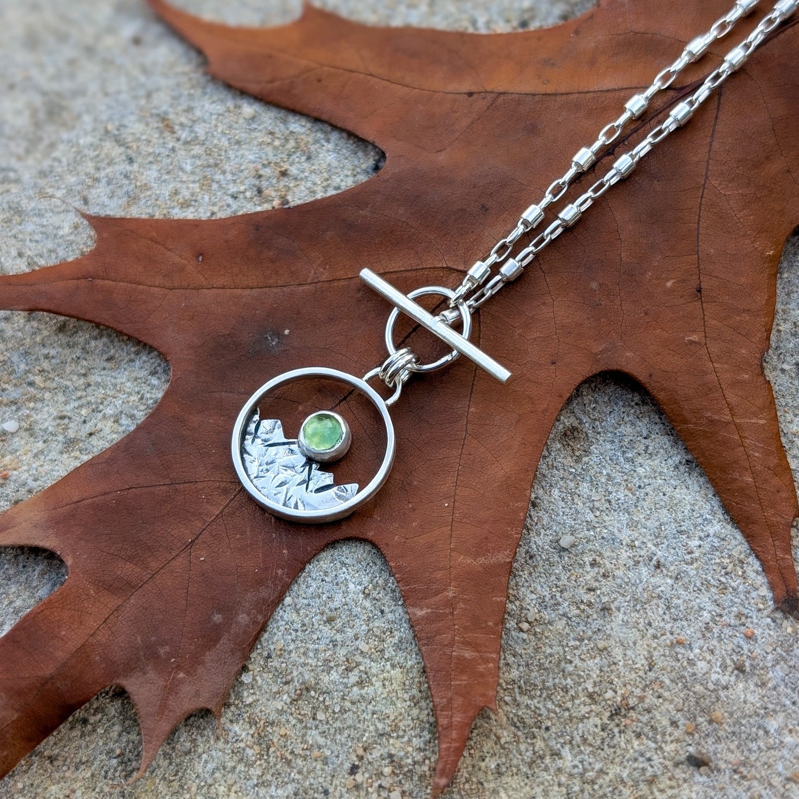 Colgante de plata con montañas y peridoto