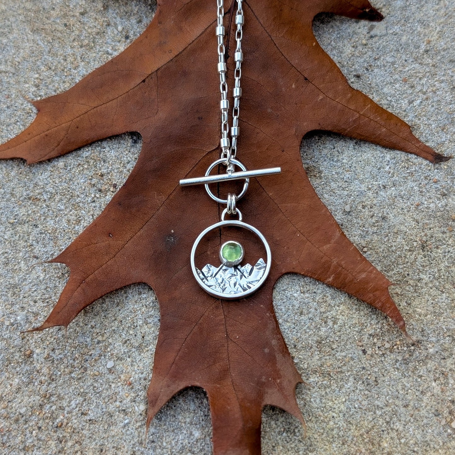 Colgante de plata con montañas y peridoto