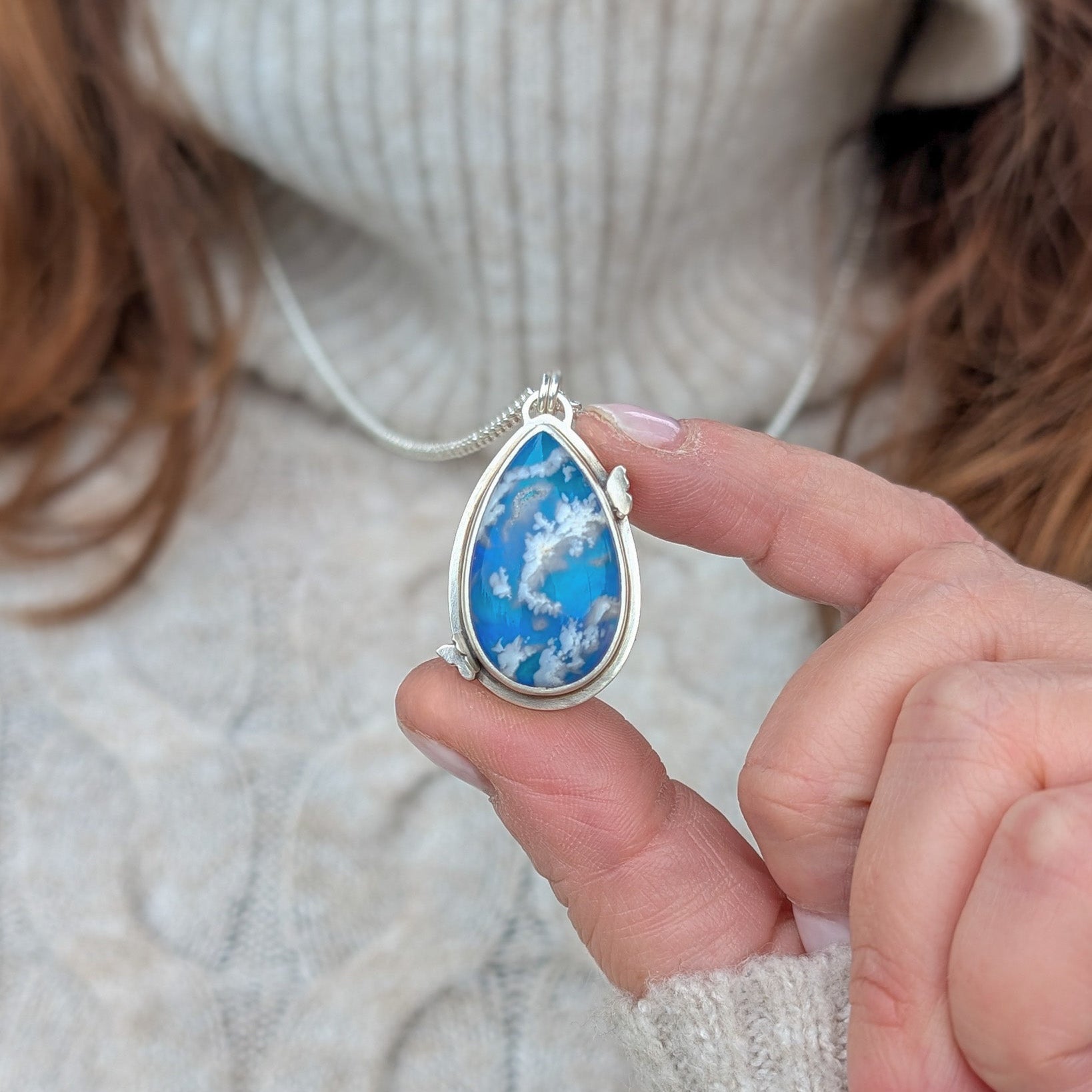 Colgante de plata y cielo con nubes