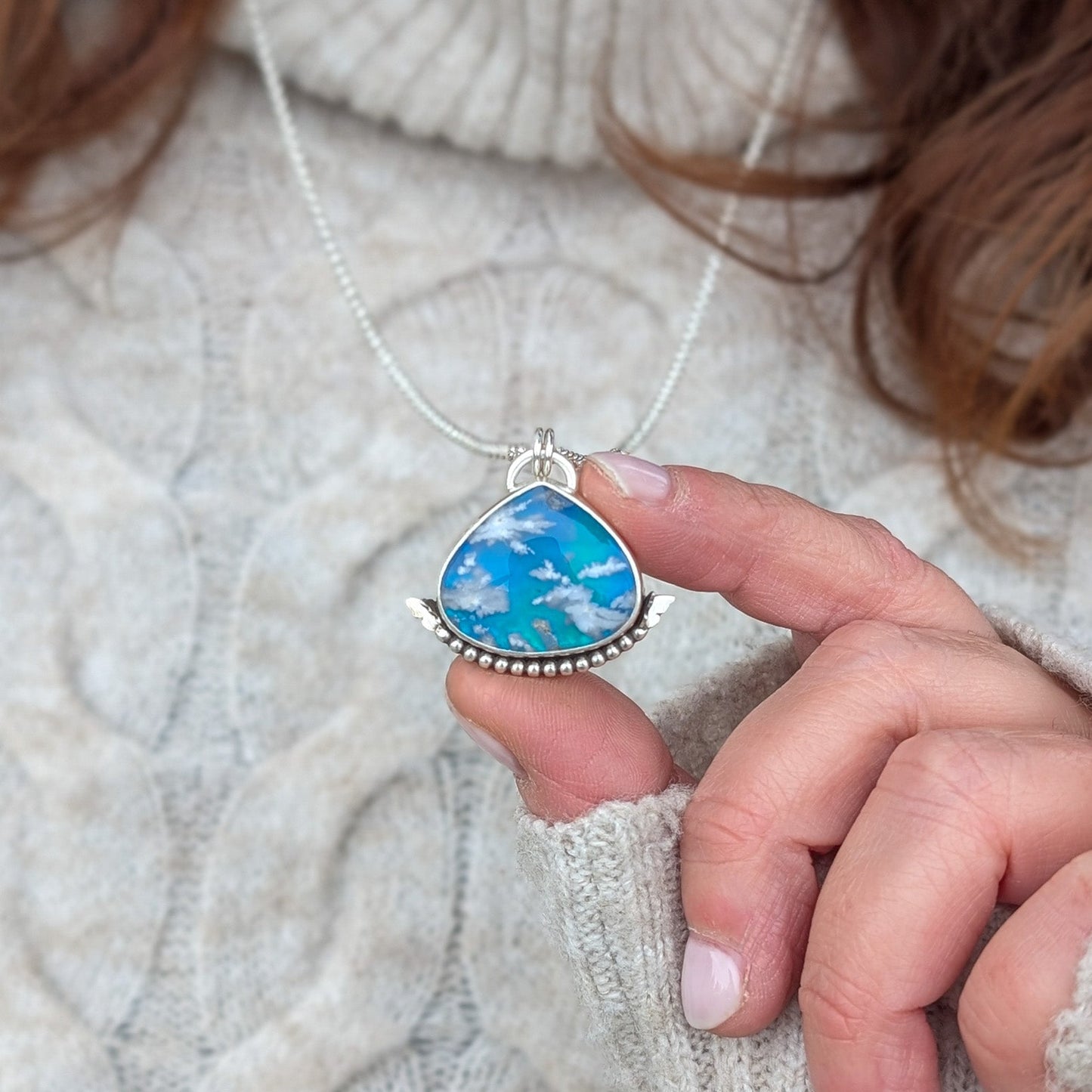 Colgante de plata y cielo con nubes
