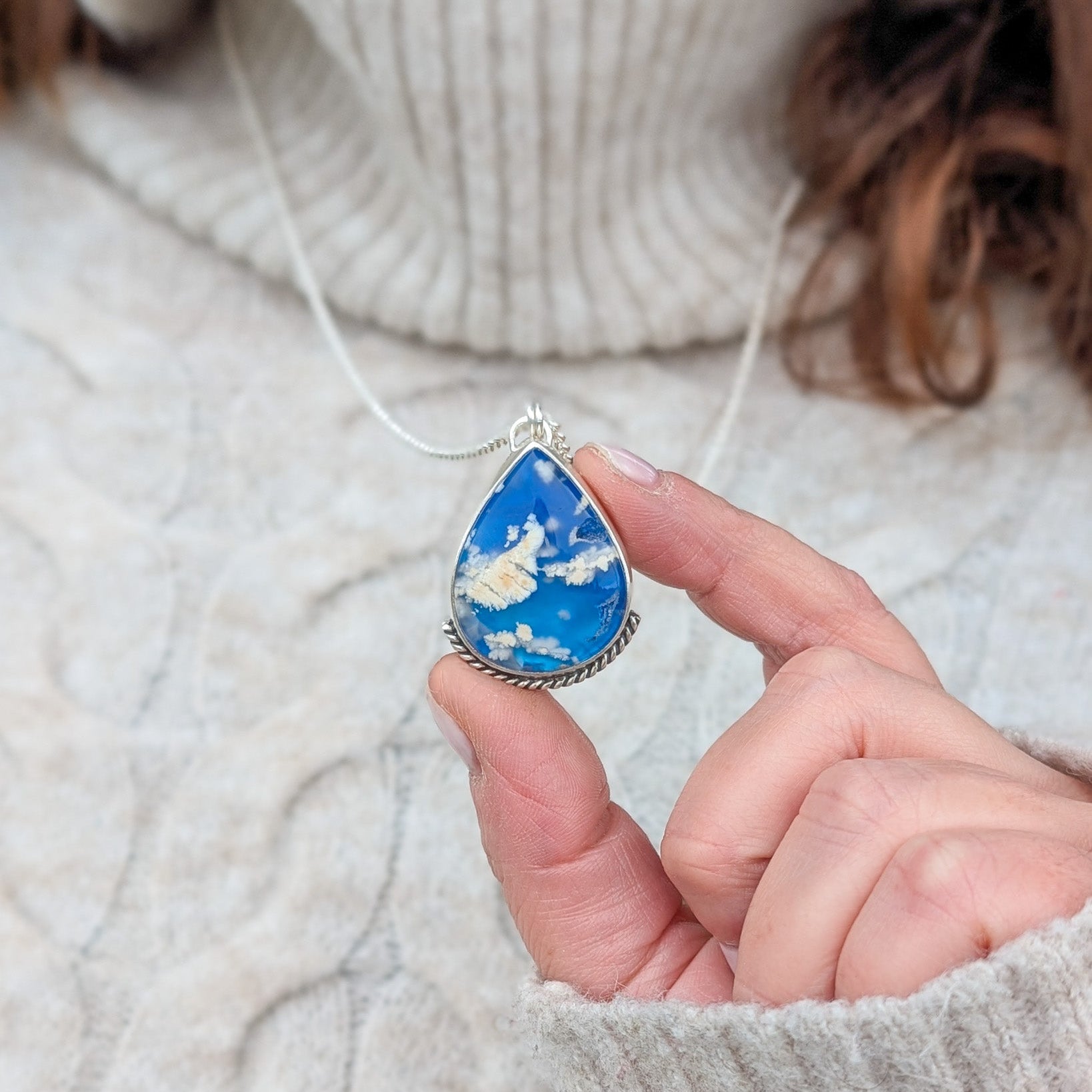 Colgante de plata y cielo con nubes