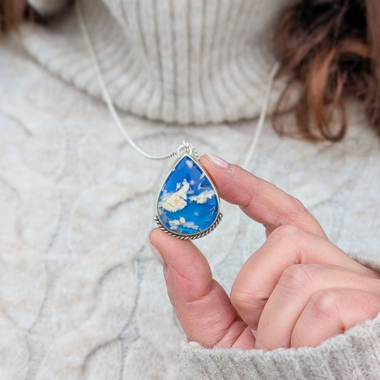 Colgante de plata y cielo con nubes